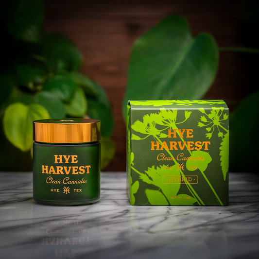 Box of Texas hemp products resting on a marble surface, framed by a lush, tree-filled backdrop.